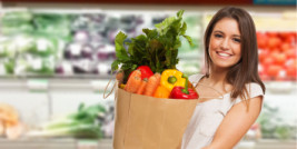 Frau im Supermarkt trägt ein Einkaufssackerl mit Gemüse darin © Minerva Studio / stock.adobe.com