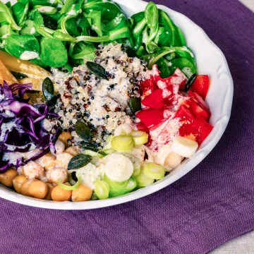 Bowl mit Kichererbsen, Rotkraut, Quinoa, Vogerlsalat, Tomaten und Paprika