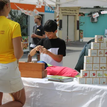 Kind am Markstand am Schlingenmarkt, CR Katharina Janecek, BSc MA / WiG