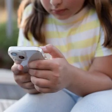 Mädchen scrollt am Smartphone